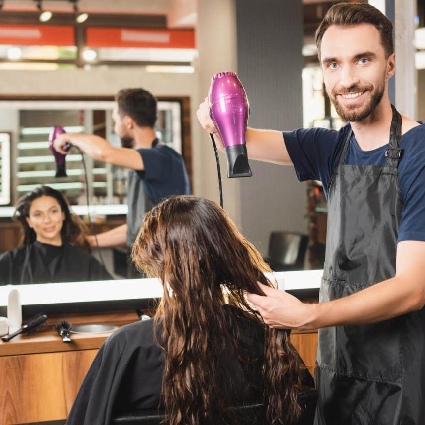 man using a hair dryer on a woman